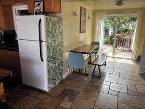 A kitchen with a refrigerator, a dining table with chairs, and a view of the outdoors through a glass door. - La Jolla Coastal Retreat Walk to the Beach, Dining and Designated Parking (San Diego)