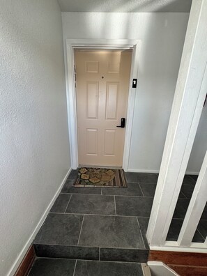 A hallway with a door, a doormat, and a staircase. - Waterfront Port Isabel/South Padre Condo for long term rent!! Sleeps 6 (Port Isabel)