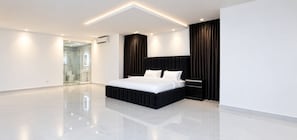 A modern bedroom with a large bed, a bedside table, and a glass shower area. - ThePeppy Apartment (Prampram)