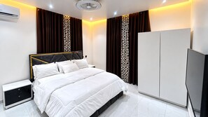 A modern bedroom with a bed, nightstands, a wardrobe, and an air conditioning unit. - ThePeppy Apartment (Prampram)