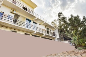 A multi-story building with balconies and air conditioning units.