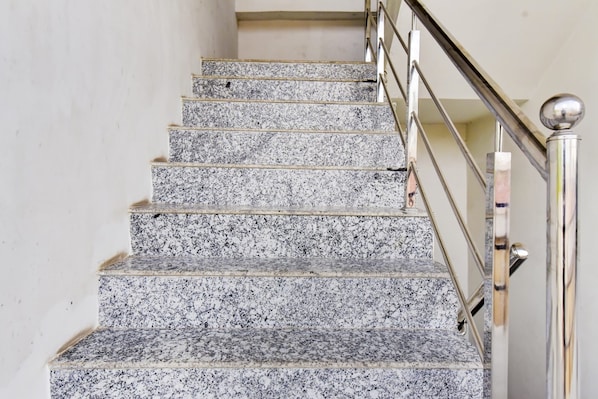 A staircase with granite steps and a metal handrail.