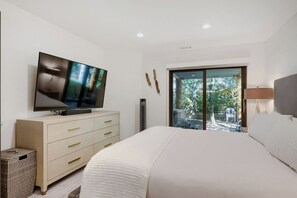 A bedroom with a bed, a television on a dresser, a window with a view of the outdoors, and a lamp. - Deer Valley Ski Retreat | Hot Tub & Fire Pit 1111 (Park city)
