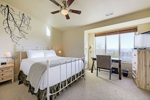 A bedroom with a bed, a desk, a chair, a ceiling fan, and a window with a view. - Bear Hollow Beauty. Hottub Walk to Free Bus 5435 (Park City)