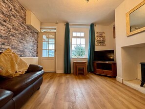 A living room with a leather sofa, a television, and a fireplace. - Silverdale Cottage-Beach, Shop and Pub all nearby. Dog Friendly (Haverigg)