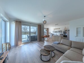 Una sala moderna con un sofá, dos mesas redondas y un comedor con sillas.