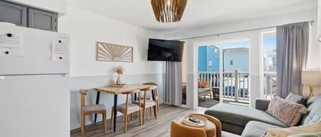 A modern apartment with a kitchen, dining area, and living room.