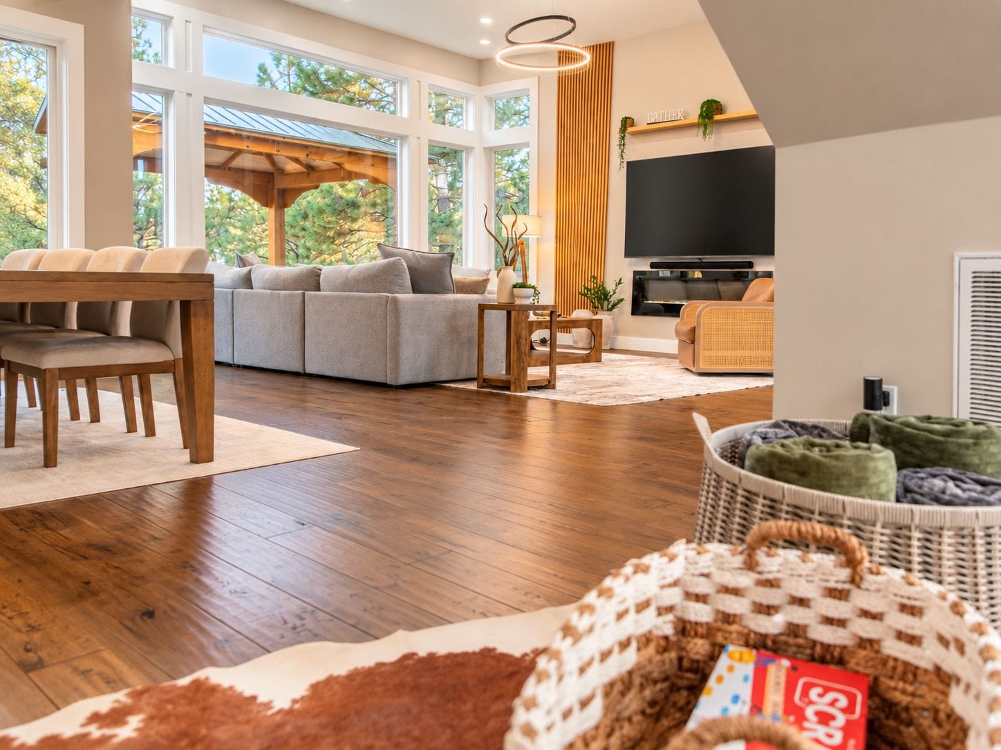 A modern living room with a sofa, a dining table with chairs, a TV, and a fireplace.