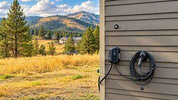 A power outlet with a charging cable on a building's exterior wall.