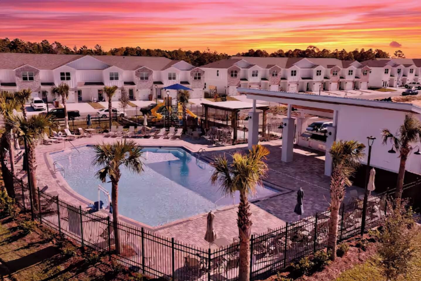 Un resort con piscina, sillas de descanso y una zona cubierta.