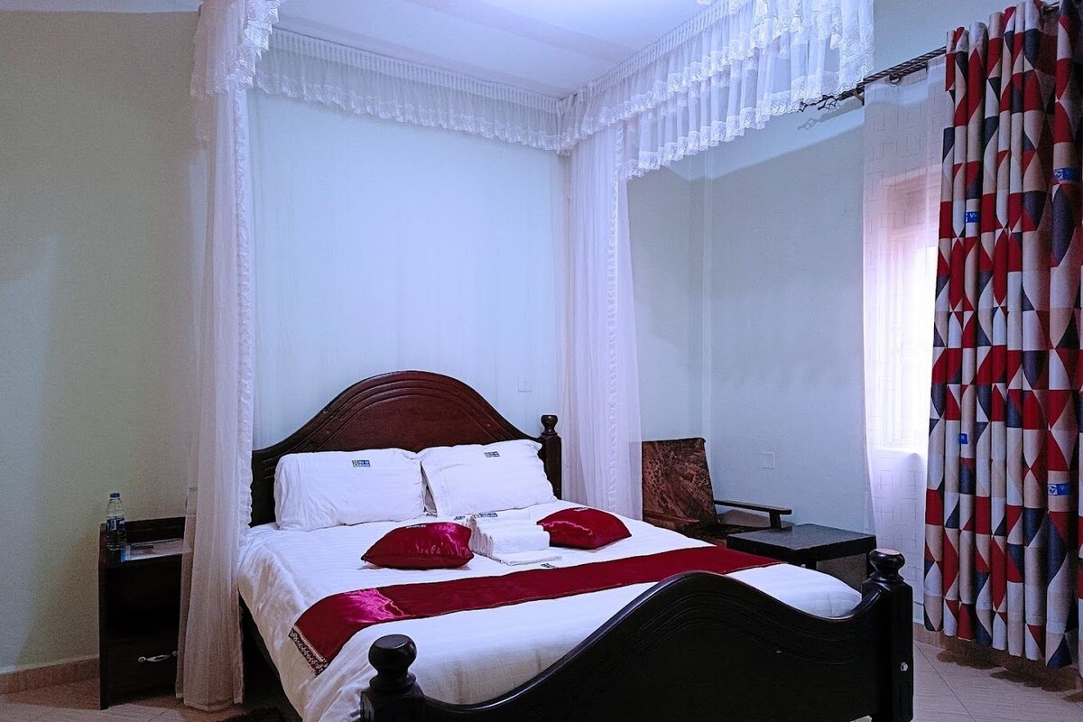A bed with a headboard, a bedside table, and a chair.