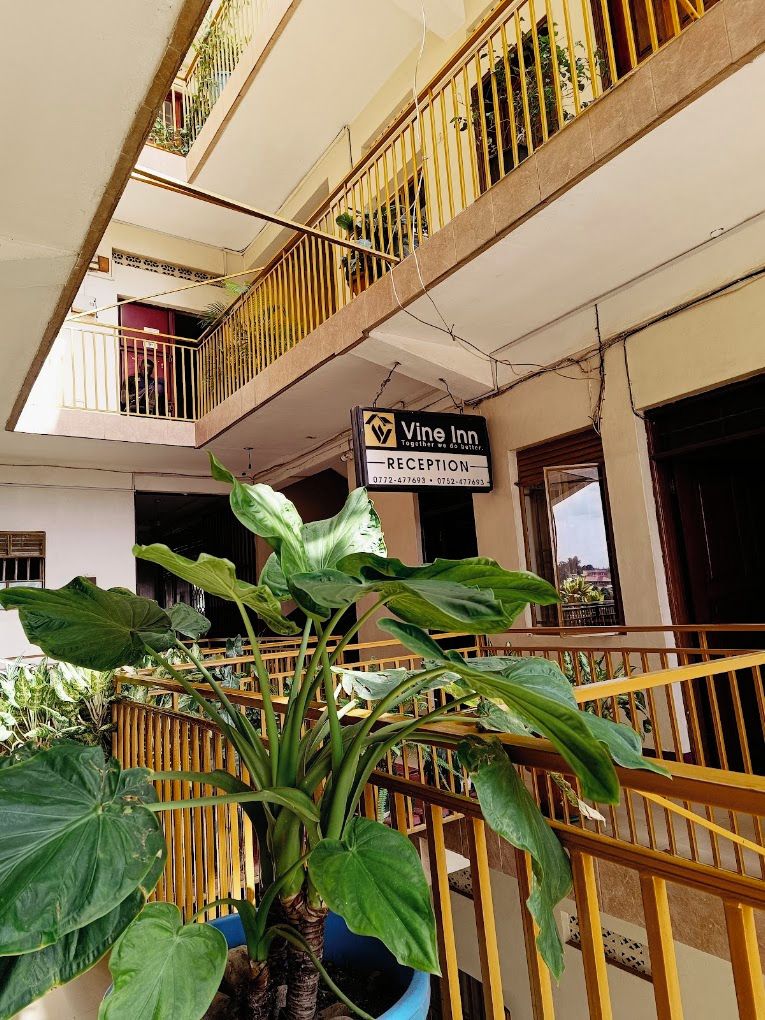 A hotel reception area with a sign for 'Vine Inn' and a staircase leading to upper floors.