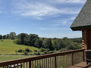 A wooden deck with a view of a green field and trees. - High Country Ranch 4300 sf Log Home, 4 bedrooms (La Crescent)