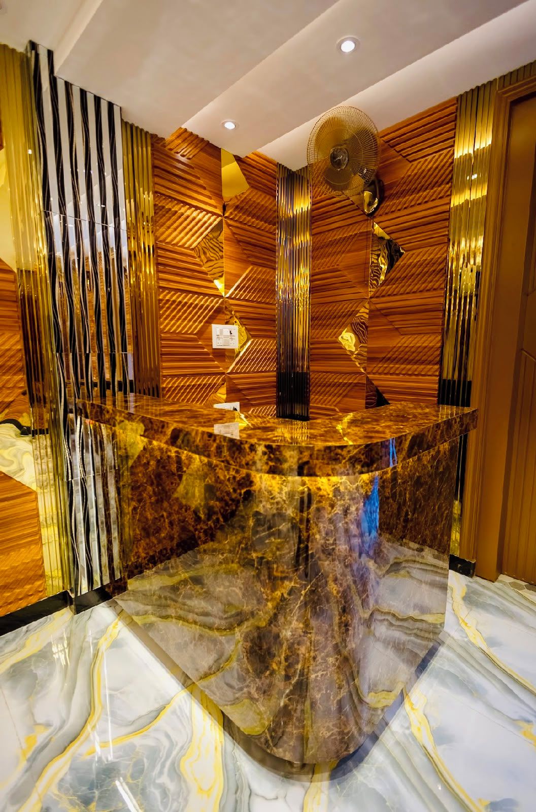 A reception area with a marble counter, wooden paneling, and a ceiling fan.