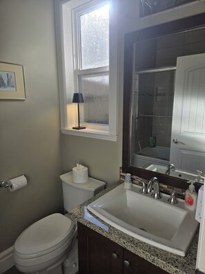 Un baño con inodoro, lavamanos y ventana.