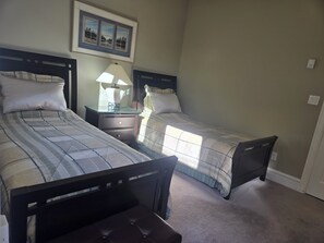 A bedroom with two beds, a nightstand, a lamp, and a framed picture on the wall. - Near YVR Airport, 5 min to City Centre, Public transit. Bedroom w/ 2 twin beds! (Richmond)