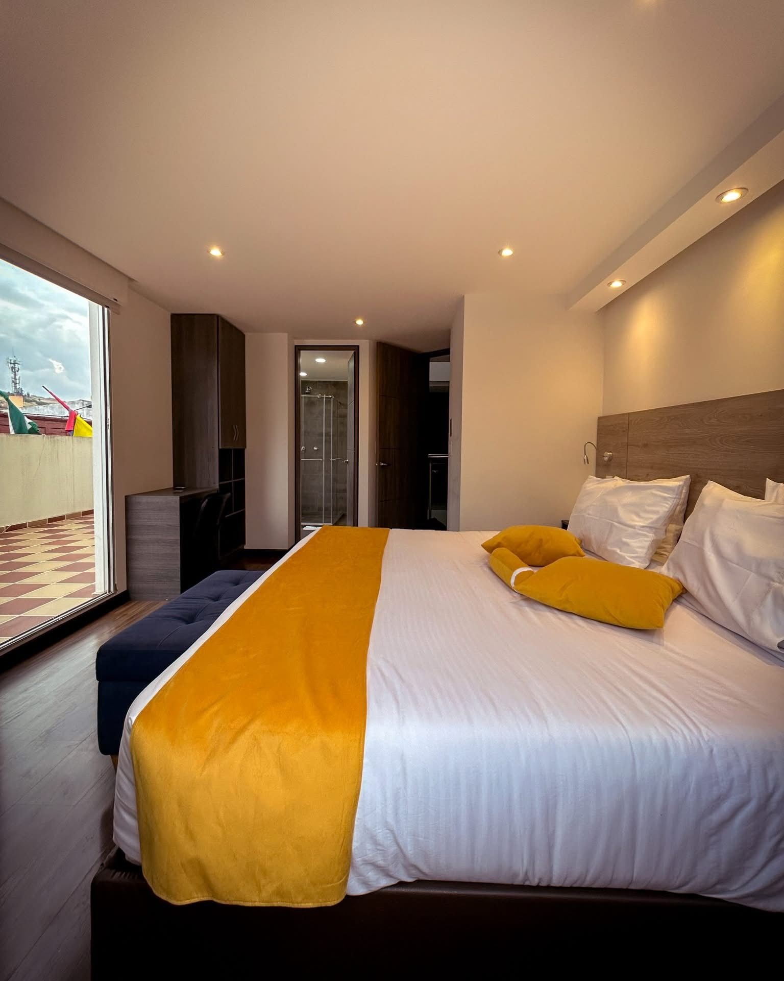 Une chambre d’hôtel moderne avec un grand lit, une vue sur la ville et un balcon.