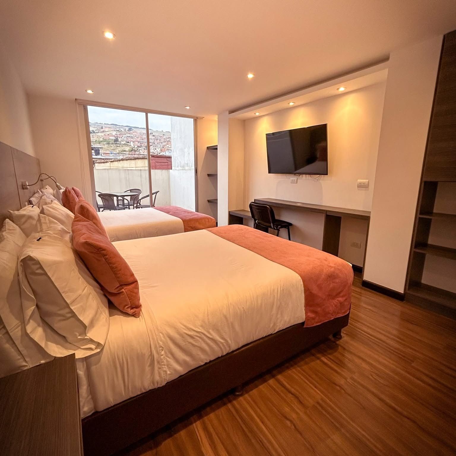 Une chambre d’hôtel avec un grand lit, un bureau, une télévision et un balcon avec vue.