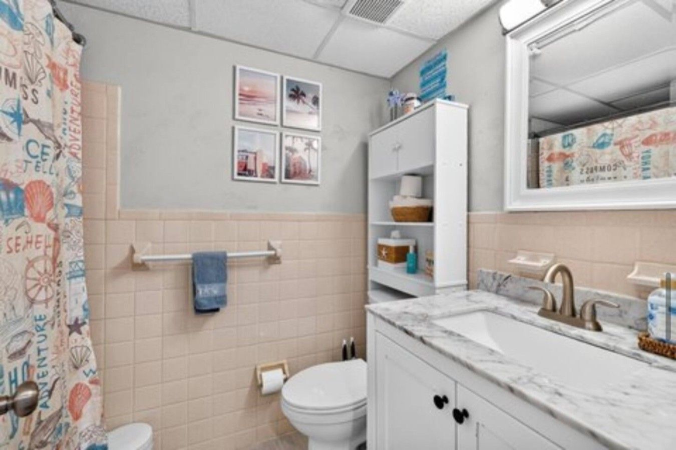 A bathroom with a toilet, sink, and a towel rack.