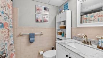 A bathroom with a toilet, sink, and a towel rack.