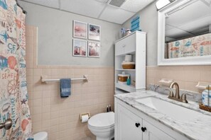 Ein Badezimmer mit Toilette, Waschbecken und Handtuchhalter.