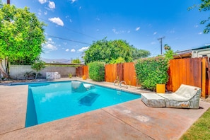 A backyard with a swimming pool, a wooden fence, and a lounge chair. - Thoughtfully Refreshed MCM.  3 Beds with Pool.  28+ day Rentals (Palm Desert)