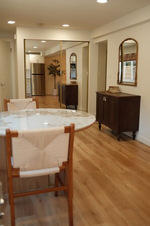 A dining area with a round table, chairs, and a cabinet. - Private 2 Bed ADU Near Airport & Hospitals (Kent)
