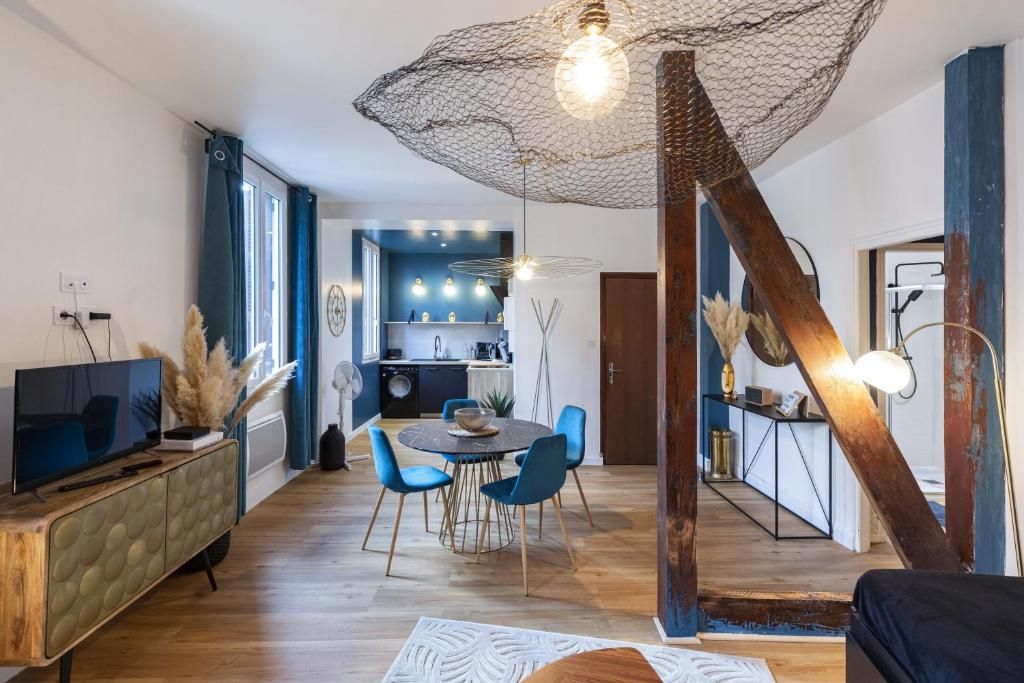 A modern living room with a dining area, wooden flooring, a TV on a cabinet, and a unique ceiling light fixture.