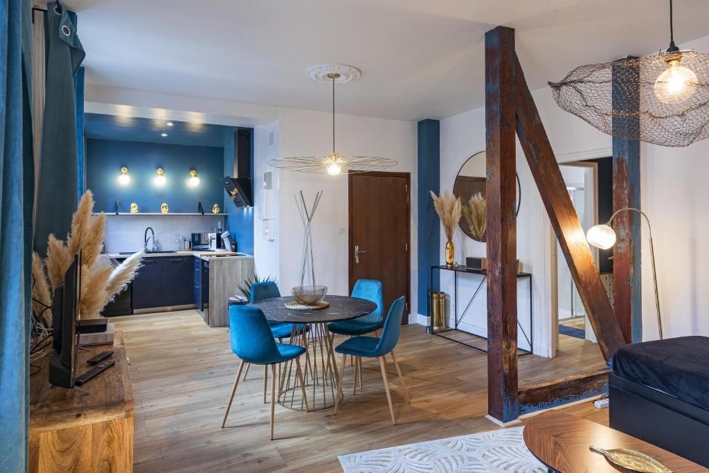 Un espacio habitable moderno con comedor, cocina y escalera.