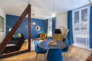 A modern living space with a bed, a dining table, and a TV. - Le Vignemale (Lourdes)