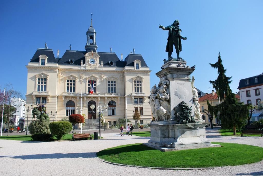 A historic building with a central courtyard, a statue, and a clock tower.