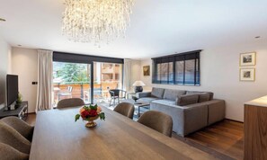 A modern living room with a dining table, sofa, and a chandelier. - CENTRAL ZERMATT APARTMENT NEAR SUNNEGGA-EXPRESS & MAIN STREET (Zermatt)