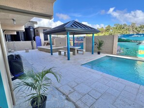 A swimming pool area with a gazebo, seating, and potted plants. - Lovely studio with AC in peaceful Lambeau (Lambeau)