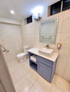 A modern bathroom with a toilet, sink, and mirror. - Lovely studio with AC in peaceful Lambeau (Lambeau)