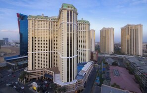 A high-rise building with multiple floors, a prominent central tower, and surrounding residential buildings. - 2BR Vegas Strip Condo at Marriott’s Grand Chateau - Special Deal: Oct 24–31 (Las Vegas)