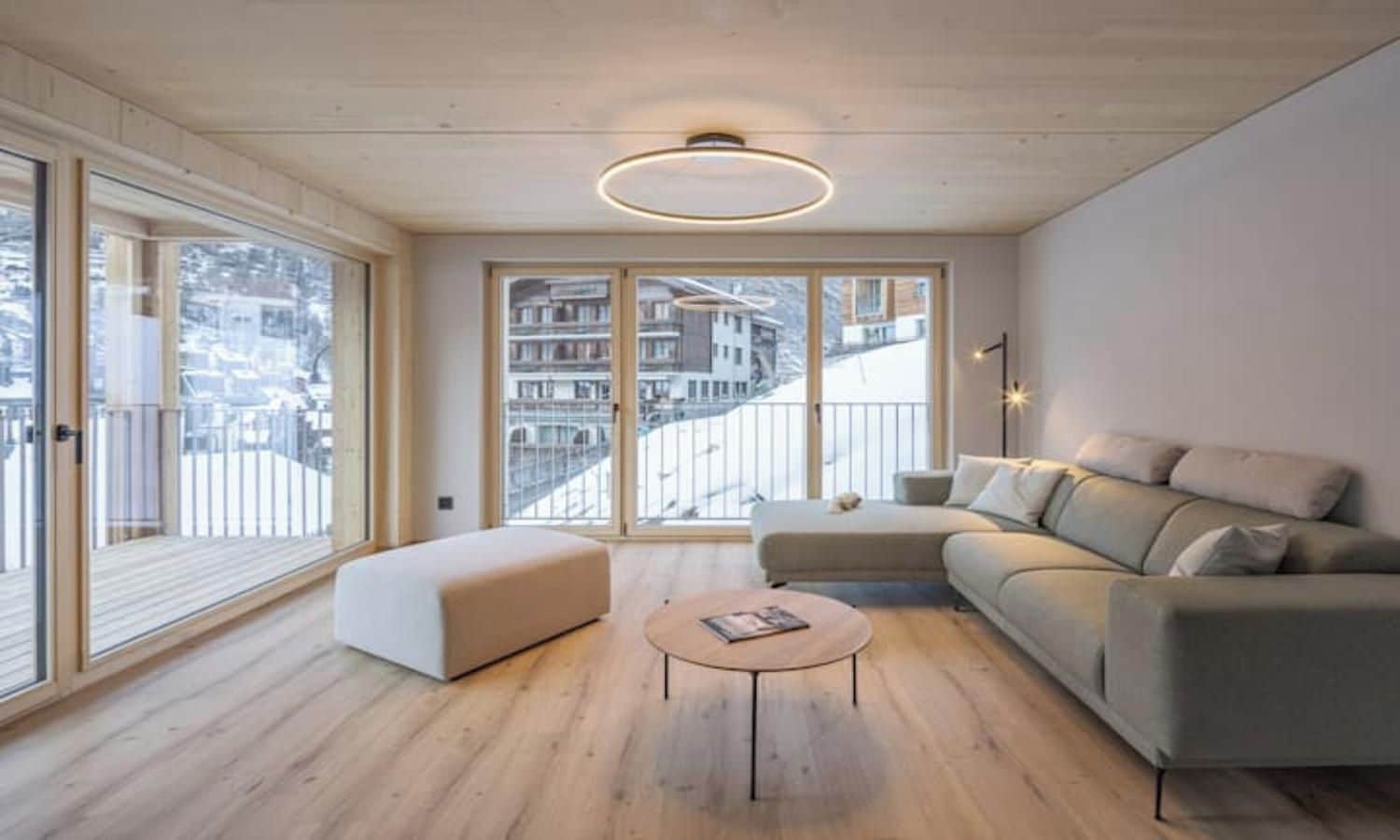 A modern living room with a sofa, ottoman, and coffee table.