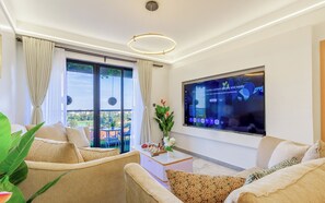 Uma sala de estar moderna com uma janela ampla, uma televisão de tela plana e uma pequena mesa com um tabuleiro de xadrez.