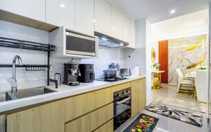 Eine moderne Küche mit Backofen, Kaffeemaschine und Mikrowelle.