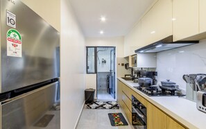A modern kitchen with stainless steel appliances, a built-in oven, and a coffee maker. - Beautiful 2-BR Riara 1 apartment near junction mall with fitness room in Nairobi (Nairobi)