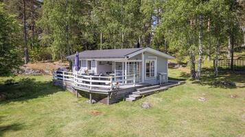 Eine Hütte mit Veranda, umgeben von Bäumen.