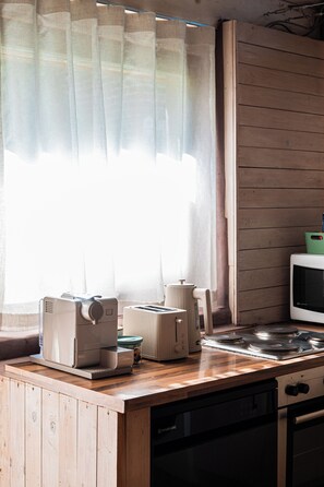 Eine Küche mit einer Holzausziehtafel, einem Toaster, einem Wasserkocher und einer Mikrowelle.