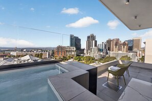 A rooftop terrace with a pool, seating area, and a city skyline view. - 2-bedroom Penthouse in the Waterkant Cape Town (Cape Town)
