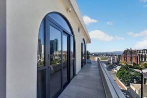 Uma varanda com grandes janelas com vista para a paisagem urbana.