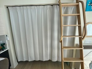 A room with a white curtain, a wooden ladder, and a shelf with items. - Perfect studio with AC in lovely Santa Cruz 
Minutes from Pleasure Point & Hwy 1 (Santa Cruz)