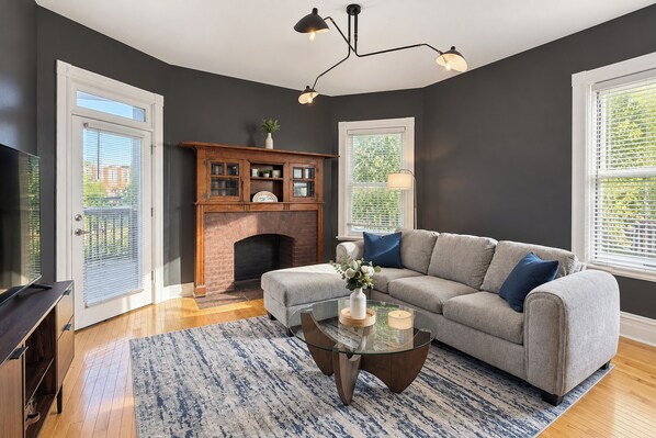 A living room with a fireplace, a sofa, a coffee table, and a television.