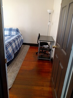 A bedroom with a bed, a desk, and a lamp. - Beautiful 3-bedroom apartment with AC in vibrant Boston (Boston)