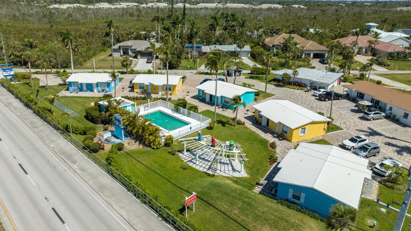 Un barrio residencial con varias casas, una piscina y una calle.