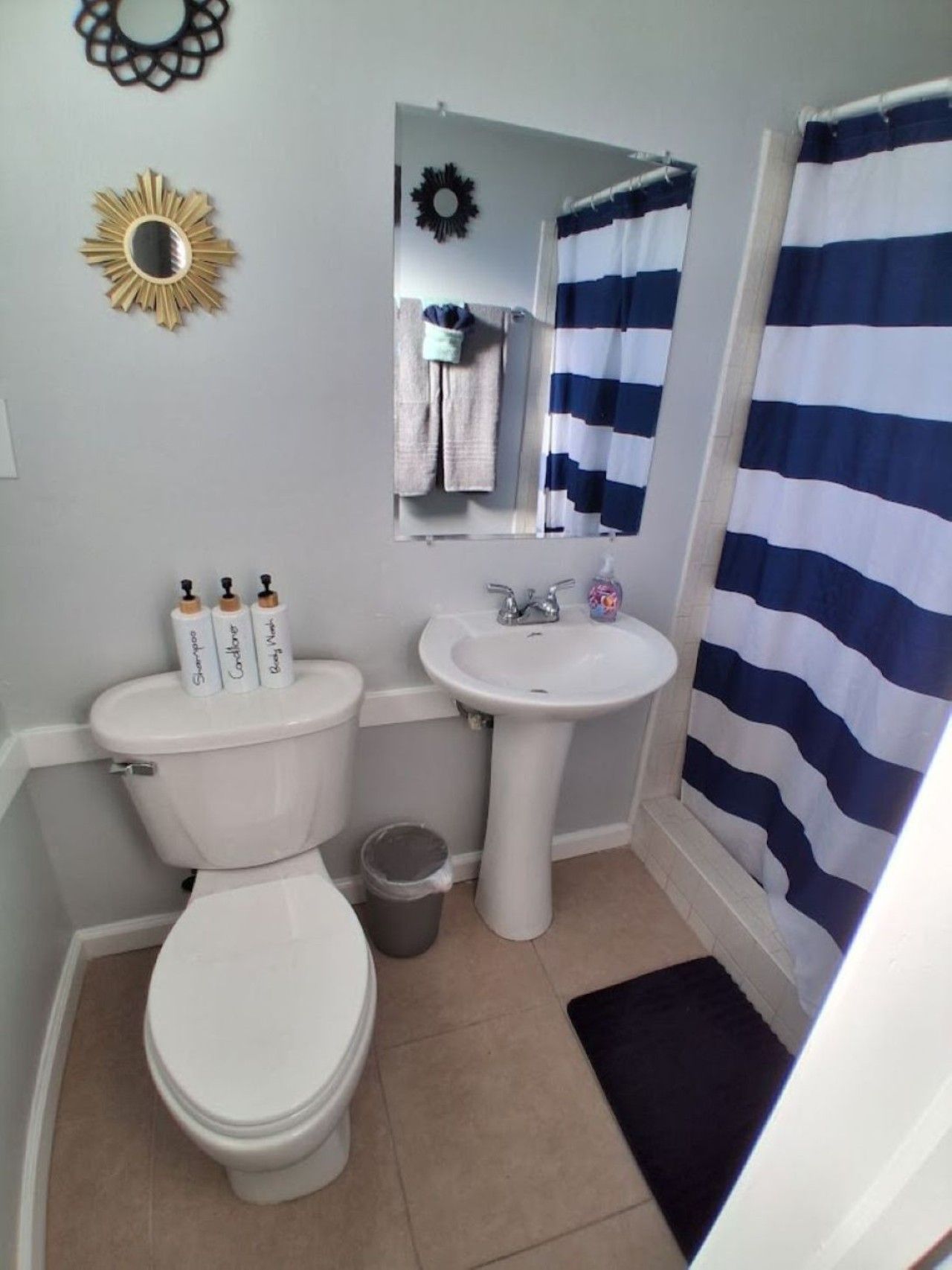 Un baño pequeño con inodoro, lavamanos y cortina de ducha.