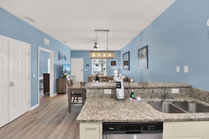 A kitchen with granite countertops, a dishwasher, and a dining area with a table and chairs. - Relaxing 3 BD/ 2 BA/ West Lucaya - 3204 GL (Kissimmee)