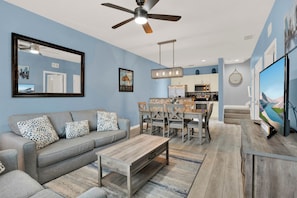 A modern living room with a sofa, coffee table, and a dining area with chairs and a table. - Relaxing 3 BD/ 2 BA/ West Lucaya - 3204 GL (Kissimmee)